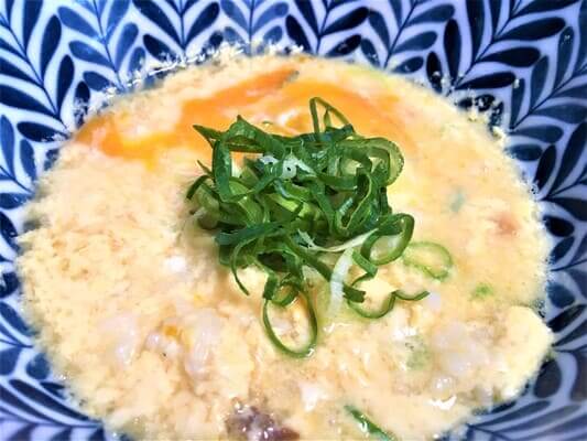 寿がきやのSugakiyaラーメンの残ったスープにご飯と卵を入れて雑炊を作り、上に刻んだねぎをのせました。
